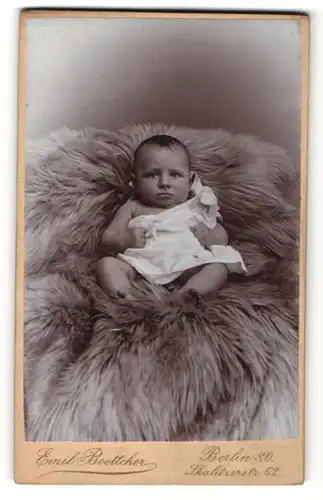 Fotografie Emil Boettcher, Berlin, Portrait Baby im Hemdchen auf einem Tierfell