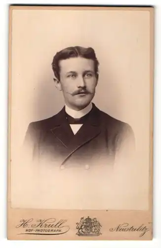 Fotografie H. Krull, Neustrelitz, Portrait charmanter junger Mann mit Mittelscheitel und Schnauzer im Jackett