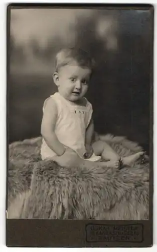 Fotografie Oskar Meister, Bautzen, süsses Kleinkind im weissen Hemdchen auf Felldecke sitzend