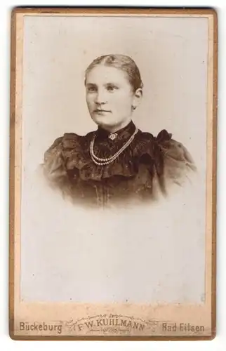 Fotografie F. W. Kuhlmann, Bückeburg, Frau mit Perlenkette und ausladendem Rüschenkleid
