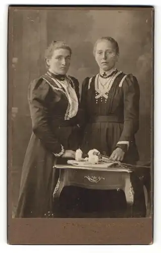 Fotografie Oscar Pöckl, München, Portrait zweier Frauen in festlichen Kleidern mit Blumen