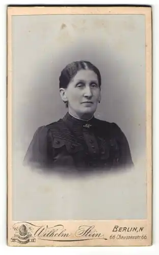 Fotografie Wilhelm Stein, Berlin, Portrait ältere Frau in bürgerlicher Kleidung mit zurückgebundenem Haar
