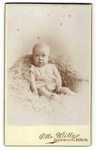 Fotografie Otto Witte, Berlin, Portrait Baby im Hemdchen auf einem Fellteppich