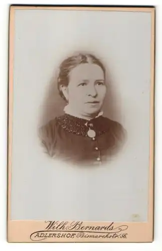 Fotografie Wilh. Bernards, Adlershof, Portrait Frau in eleganter Kleidung mit zurückgebundenem Haar