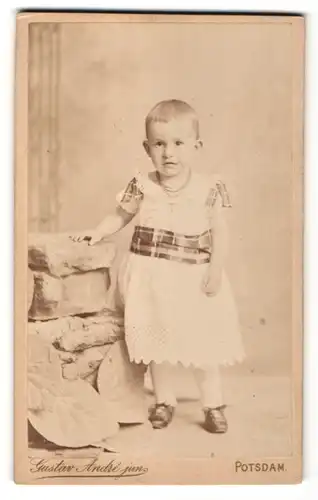 Fotografie Gustav Andre jun., Potsdam, Portrait kleines Mädchen im Spitzenkleid mit Kreuzkette