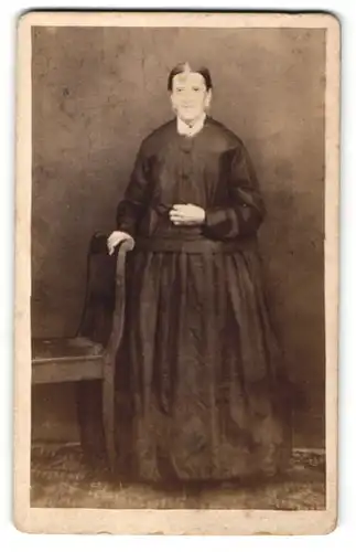 Fotografie M. J. Wagner, Furth a. / Wald, Portrait Frau in zeitgenössischer Kleidung am Stuhl