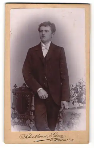Fotografie Scheithauer & Giese, Zwickau i. / S., Portrait junger Mann mit Locken und Fliege im Anzug