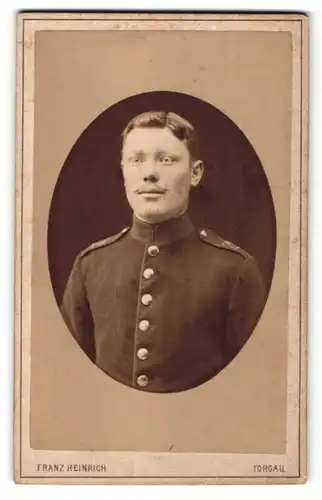 Fotografie Franz Heinrich, Torgau, Portrait junger Soldat mit charmantem Blick in Uniform