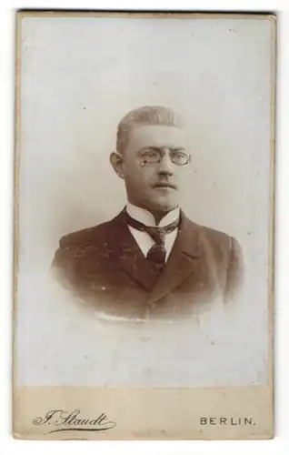 Fotografie Julius Staudt, Berlin, Portrait Mann mit Zwicker und Krawatte im Anzug