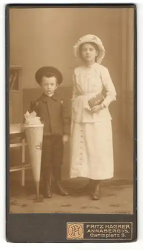 Fotografie Fritz Hacker, Annaberg i. / S., Portrait Mädchen im weissen Kleid und kleiner Junge mit Schultüte