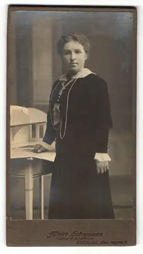 Fotografie Albert Schumann, Stendal, Portrait Frau mit zurückgebundenem Haar im Samtkleid mit Halstuch