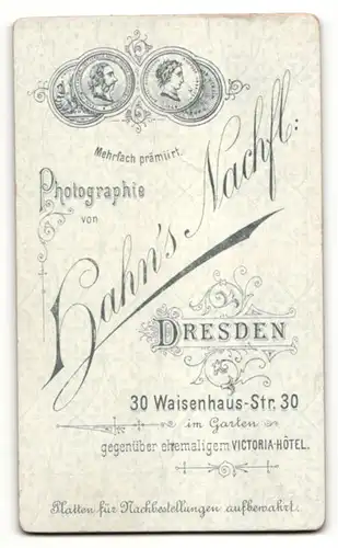 Fotografie Hahn's Nachf., Dresden, charmant lächelndes Fräulein mit Blume im gerüschten Kleid