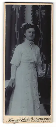 Fotografie Franz Gleitz, Gardelegen, dunkelhaariges Fräulein mit weisser Haarschleife im Kleid mit Schleifen