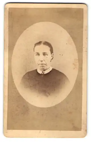Fotografie S. Sönning, Lauingen, Portrait dunkelhaarige Dame mit zurückgebundenem Haar und Brosche am Kragen