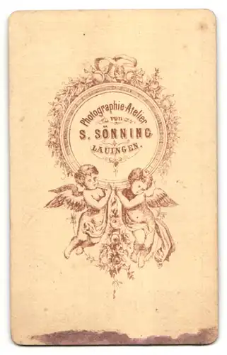 Fotografie S. Sönning, Lauingen, Portrait dunkelhaarige Dame mit zurückgebundenem Haar und Brosche am Kragen