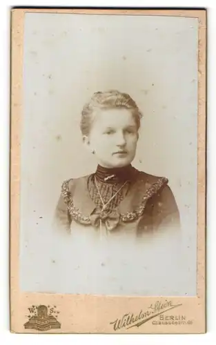 Fotografie Wilhelm Stein, Berlin, Portrait blondes Fräulein mit Brosche, Halskette und zurückgebundenem Haar