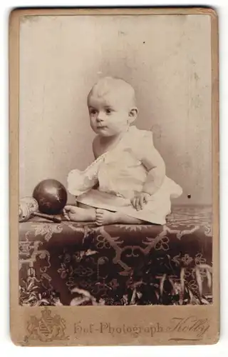 Fotografie Kolby, Chemnitz, süsses Baby mit Ball im weissen Kleidchen