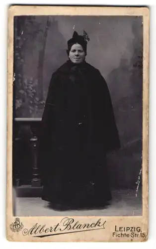 Fotografie Albert Blanck, Leipzig, elegante Dame im schwarzen Mantel und Hut