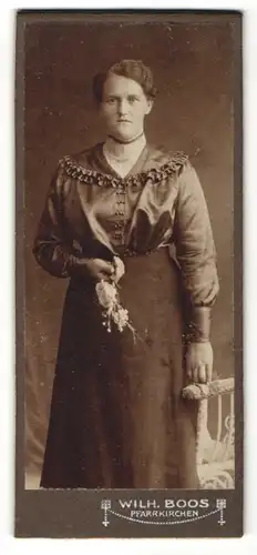 Fotografie Wilh. Boos, Pfarrkirchen, Portrait hübsche junge Frau mit Blume im gerüschten Kleid
