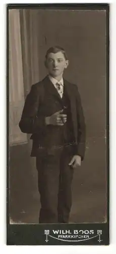 Fotografie Wilh. Boos, Pfarrkirchen, Knabe mit brünettem Haar und Zigarillo im Anzug