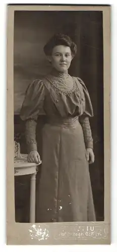 Fotografie August Lutz, Gera, lächelnde junge Frau mit hochgebundenem Haar im besticktem Kleid