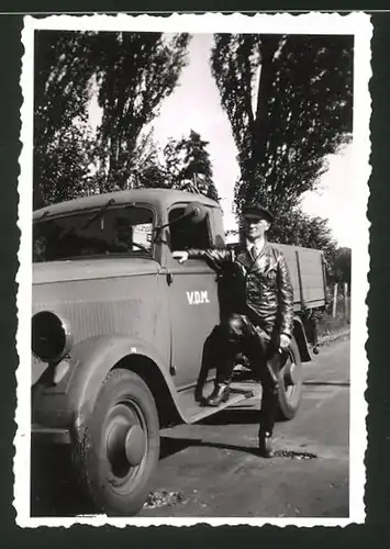 Fotografie Lastwagen - Pritsche, Kraftfahrer mit Ledermantel lehnt am LKW, V.D.M.