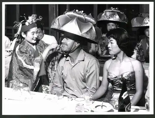 Fotografie Japan, japanische Damen setzen Amerikaner Trachten-Hut auf