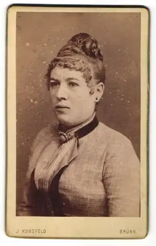 Fotografie J. Kunzfeld, Brünn, Portrait hübsches Fräulein mit hochgestecktem Haar und Brosche am Kragen