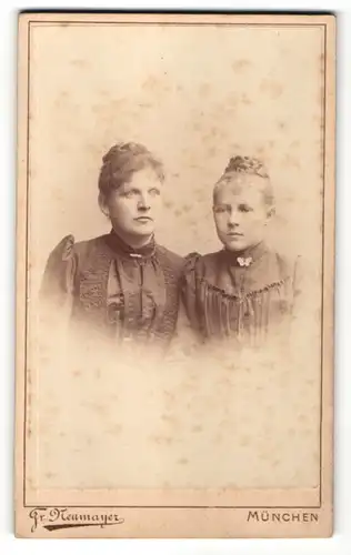 Fotografie Fr. Neumayer, München, Portrait zwei wunderschöne junge Damen mit Flechtfrisuren und Broschen am Kragen