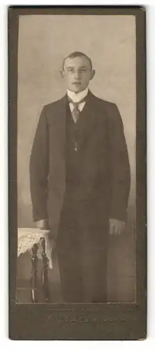 Fotografie Wilh. Lüder, Ort unbekannt, Portrait junger Mann mit Krawatte im Anzug