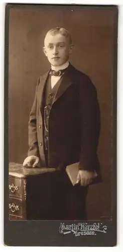 Fotografie Martin Herzfeld, Dresden, Portrait blonder junger Mann mit Fliege und Buch im Jackett