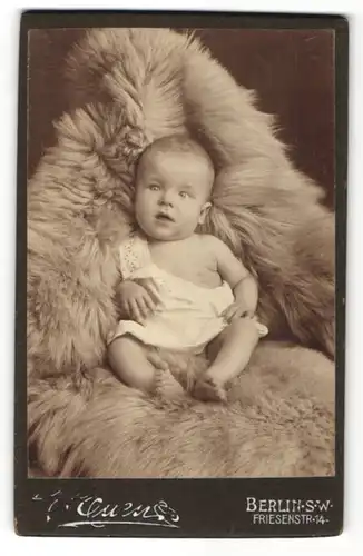 Fotografie Unbekannter Fotograf, Berlin S. W., Portrait Baby im weissen Hemdchen auf einem Fell