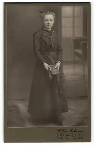 Fotografie Müller-Hoffmann, Freiberg i. S., schönes Fräulein mit Haarschleife und Buch im eleganten Kleid