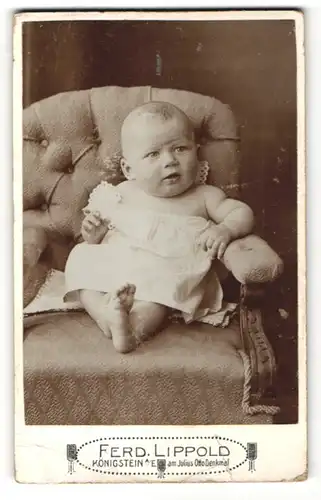 Fotografie Ferd. Lippold, Königstein a. E., zuckersüsses Baby im weissen Hemdchen mit nackten Füssen