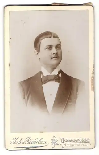 Fotografie Joh. Röckelein, Donauwörth, Portrait junger Mann mit ungewöhnlichem Haarschnitt und schwarzer Fliege