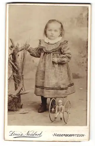 Fotografie Louis Neubert, Niederbobritzsch, Portrait kleines Mädchen mit Blechspielzeug