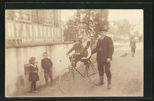Foto-AK Mann schiebt zwei Kinder auf seinem Fahrrad über die Strasse