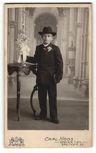 Fotografie Carl Hoos, Speyer a/Rh, Portrait Bub in feierlicher Kleidung mit Hut und Kerze