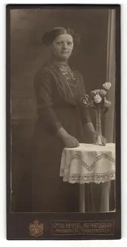 Fotografie Otto Hertel, Freiberg i/S, Portrait Dame in Kleid nebst Blumenvase