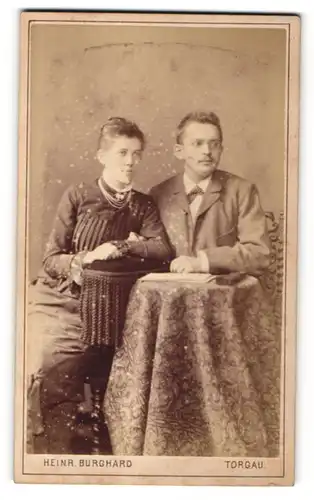Fotografie Heinr. Burghard, Torgau, Portrait junges Paar in zeitgenöss. Kleidung