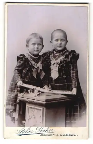 Fotografie Atelier Becker, Cassel, Portrait zwei kleine Mädchjen in identischen Kleidern, Schwestern