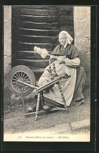 AK Frau sitzt am Spinnrad vor ihrem Haus