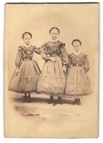 Fotografie drei Mädchen in identischen Kleidern, Schwestern
