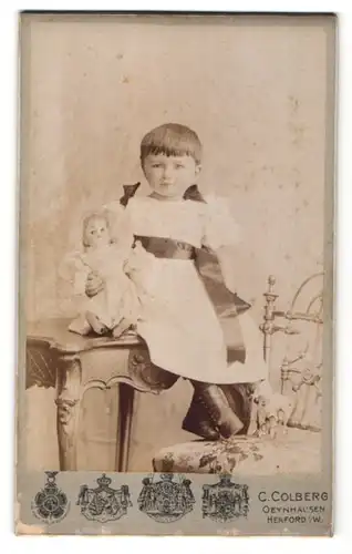 Fotografie C. Colberg, Oeynhausen & Herford i/W, Portrait kleines Mädchen mit Puppe