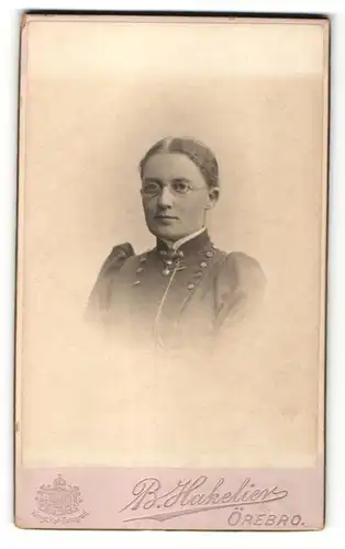 Fotografie B. Hakelier, Örebro, Portrait Frau mit Brille in zeitgenössischem Kleid