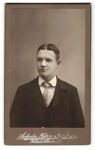 Fotografie Asheda, Norrhult, Portrait junger Mann mit Krawatte im Anzug