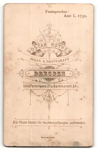 Fotografie Osc. Rothe, Dresden-Friedrichstadt, Portrait Kleinkind im weissen Kleid auf einem Fell