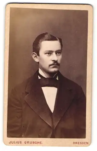 Fotografie Julius Grusche, Dresden, Portrait Mann mit Fliege und Schnurrbart im Anzug