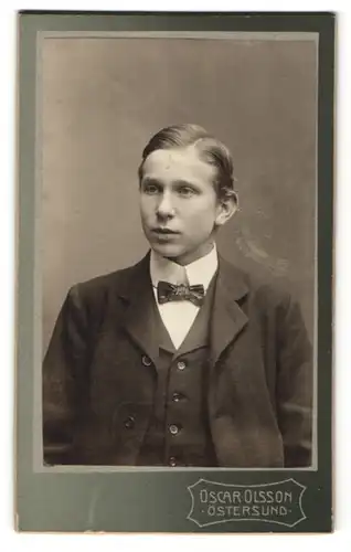 Fotografie Oscar Olsson, Östersund, Portrait Junge mit Fliege im Anzug