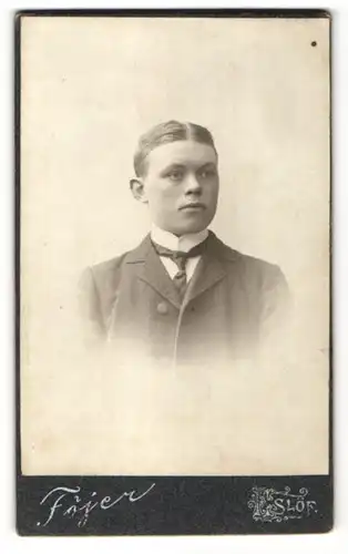 Fotografie Atelier Fojer, Eslöf, Portrait blonder junger Mann mit Scheitel und charmantem Blick